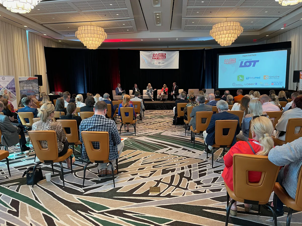 Audience in a hotel ballroom facing a panel on stage at the 60 Million Congress, with LOT Polish Airlines shown as main partner