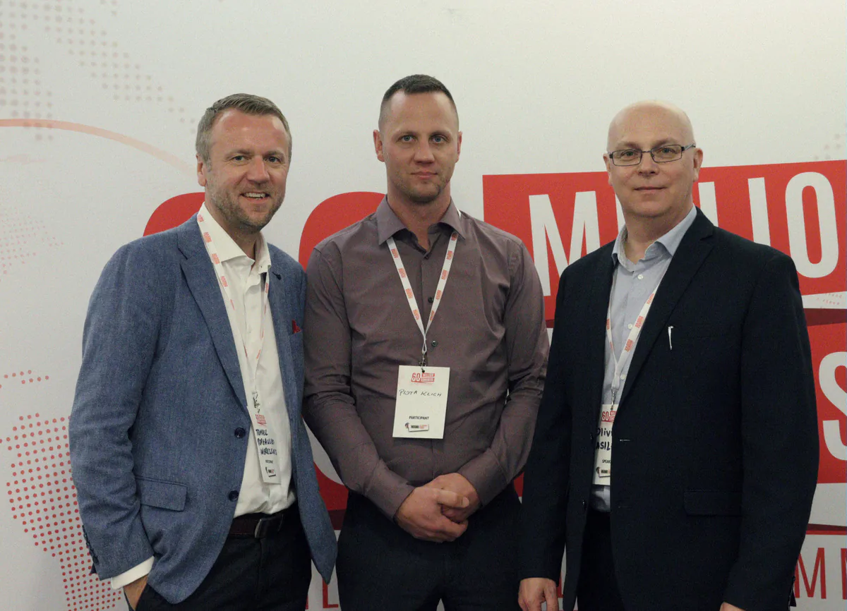 Tomasz Popławski, Piotr Klich and Olivier Wasilewski with conference badges in front of the 60 Million Congress backdrop