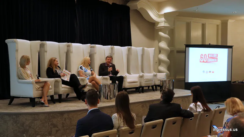 Four panelists in tall white armchairs on stage beside a screen with the 60 Million Congress logo