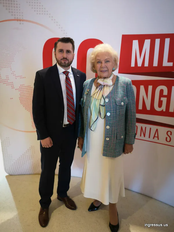Two congress guests posing in front of the 60 Million Congress backdrop