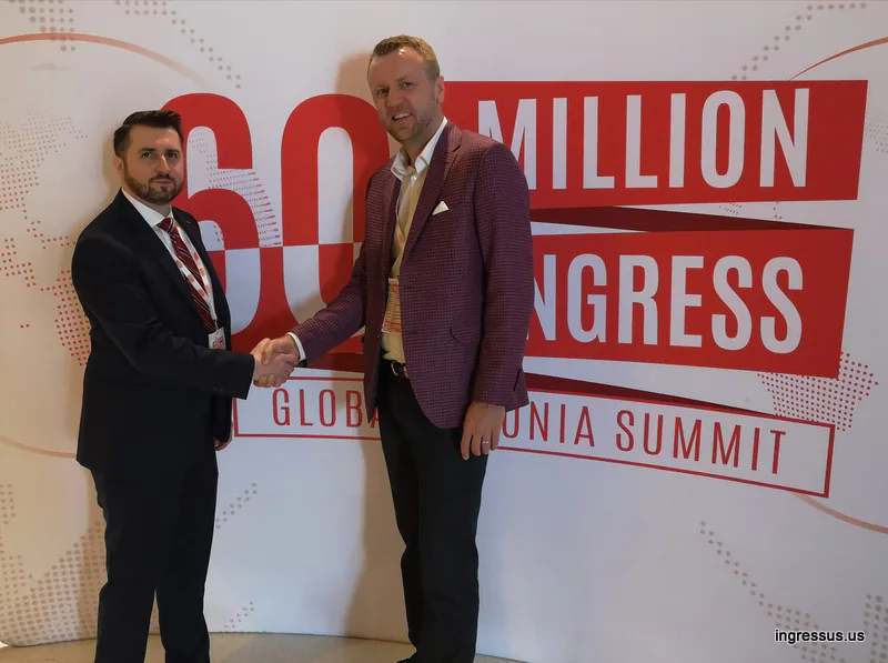 Two congress participants shaking hands in front of the 60 Million Congress Global Polonia Summit backdrop