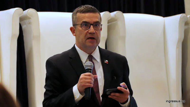 Speaker with a microphone and a phone addressing the 60 Million Congress audience from the stage in Miami Beach