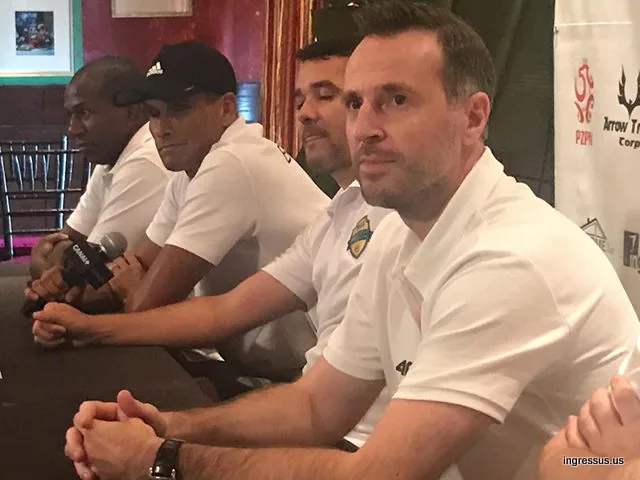Players in white polo shirts seated at the Soccer Legends Cup press conference table, with a Canal+ microphone in front of them