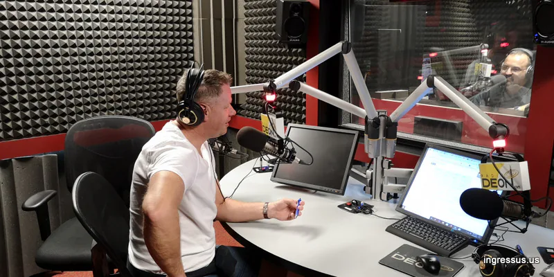 Radio interview at the Deon radio studio, with a guest at the microphone and the host behind the glass