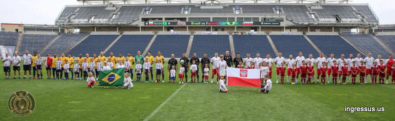 Panorama of the Brazil and Poland Legends teams lined up with youth escorts and national flags at SeatGeek Stadium