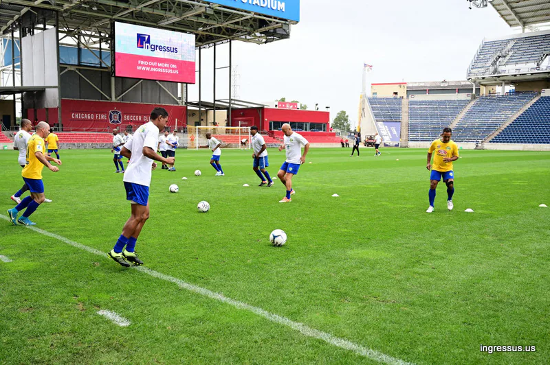 Players warming up on the pitch at SeatGeek Stadium, with an Ingressus ad on the video board above the stand
