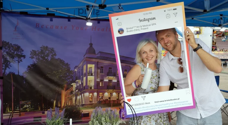 Two people posing with an Instagram-style frame of Bristol Art & Medical Spa, Busko-Zdrój, at its booth at Polonaise Festival 2019 in Chicago