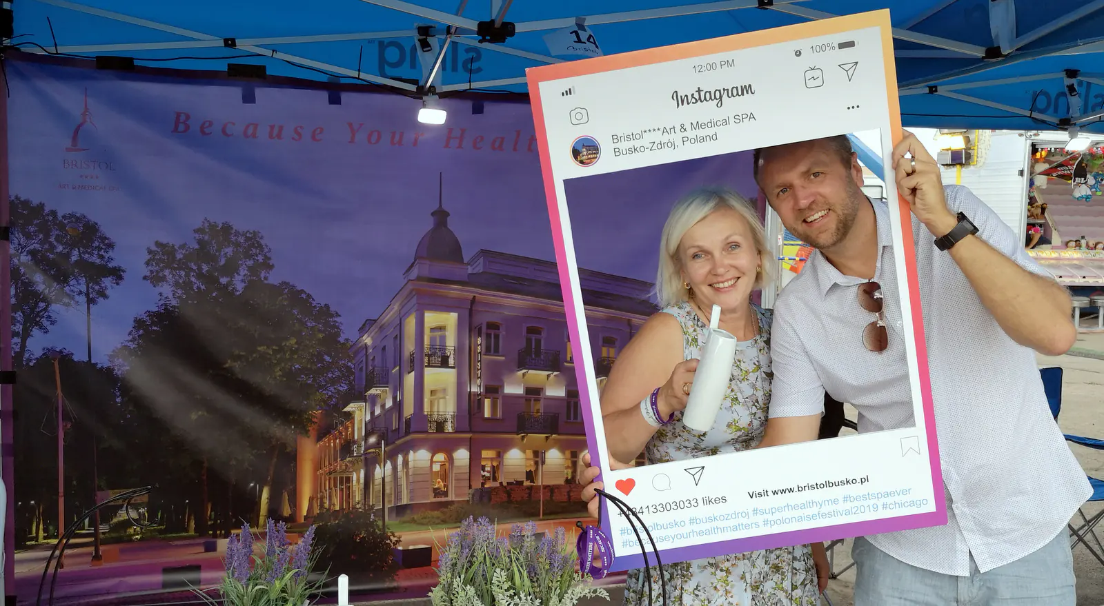 Dorota Tworek and Tomasz Popławski posing with a Bristol Art & Medical Spa Instagram-style frame at the Polonaise Festival booth
