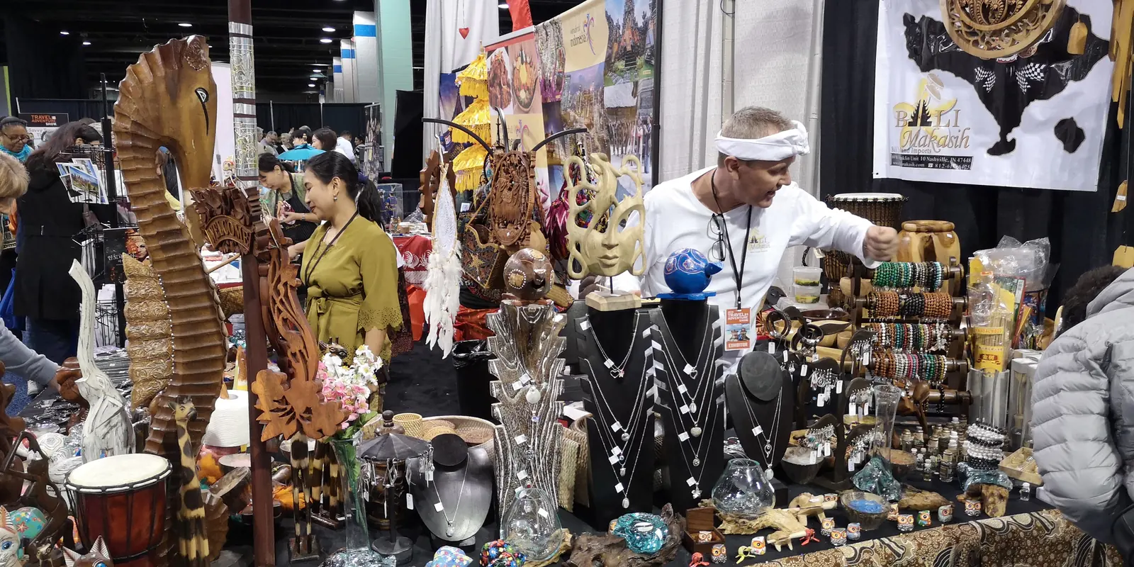 Booth with Balinese wood carvings, masks, drums and jewelry at the Chicago Travel & Adventure Show 2019 in Rosemont
