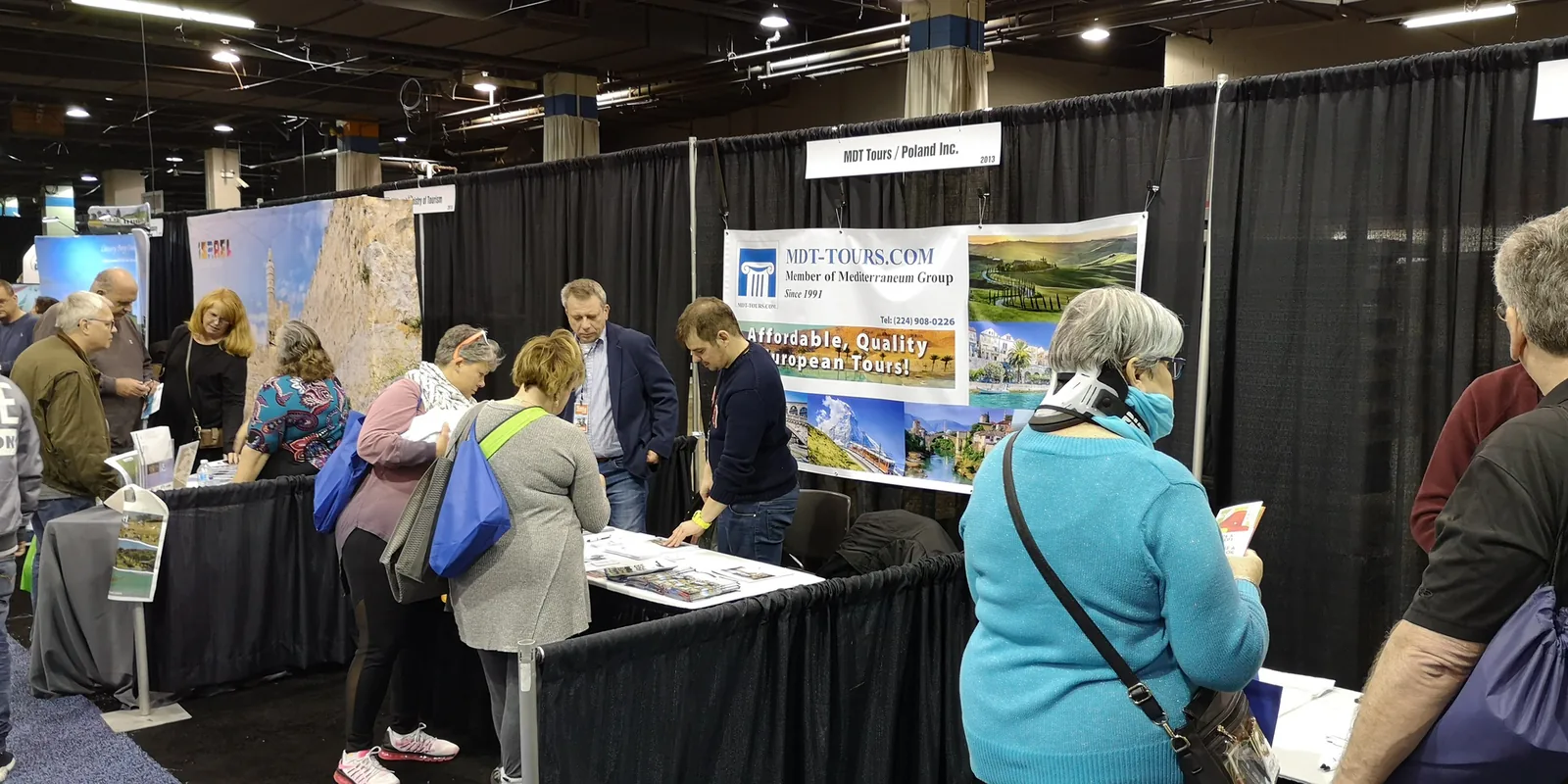 Visitors browsing brochures at the MDT Tours / Poland Inc. booth offering European tours at the Chicago Travel & Adventure Show 2019