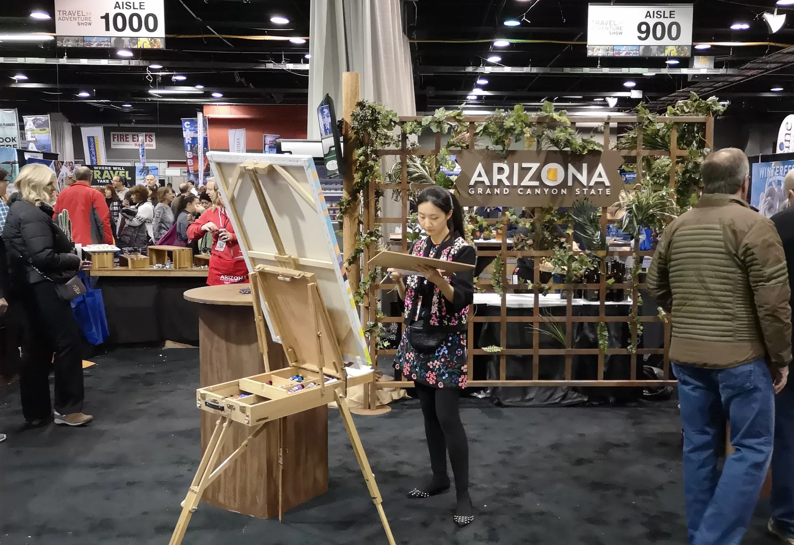 Artist painting at an easel in front of the Arizona Grand Canyon State booth at the Chicago Travel & Adventure Show 2019