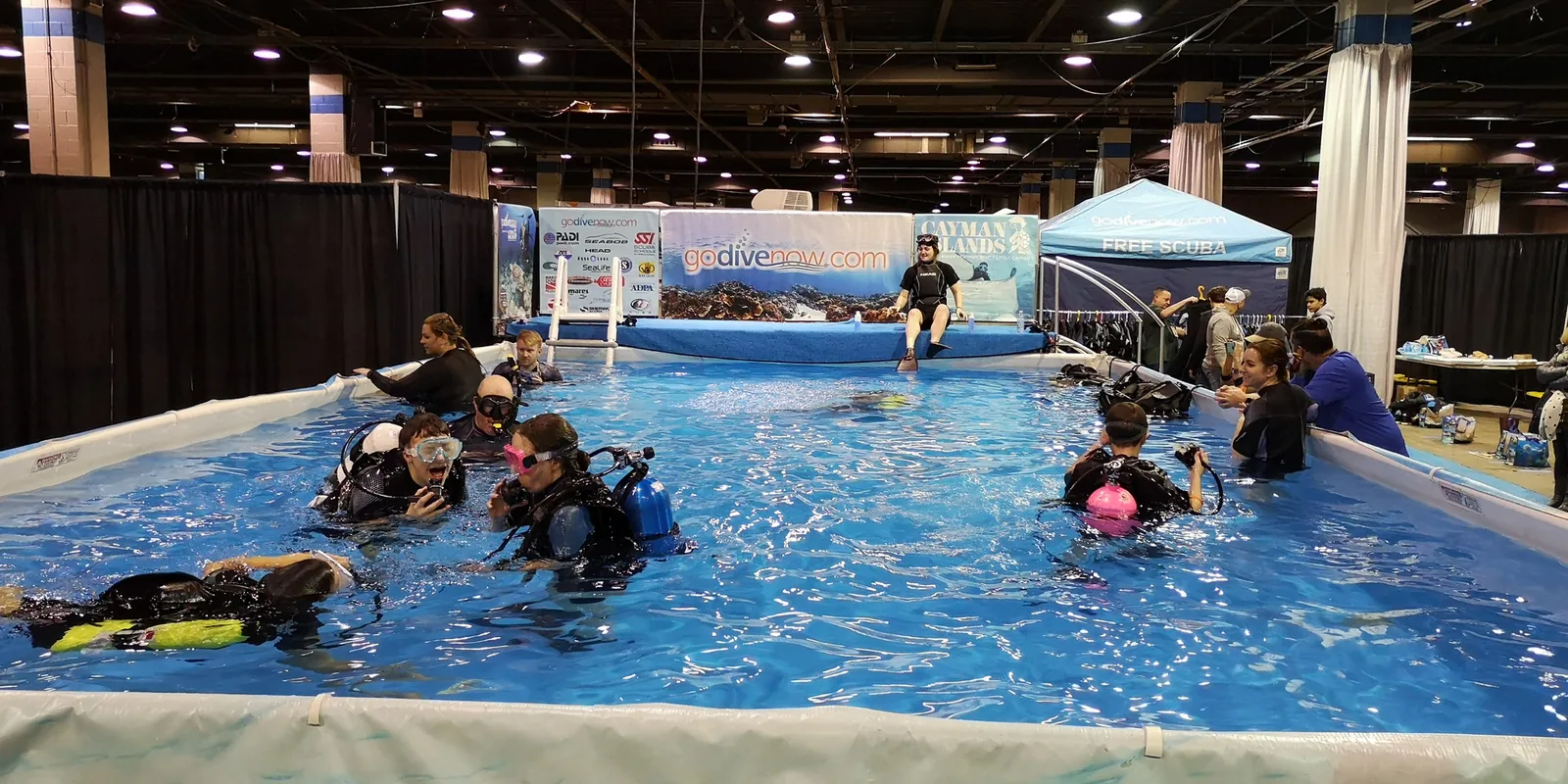 Visitors trying scuba diving in an indoor pool at the Go Dive Now free scuba area of the Chicago Travel & Adventure Show 2019