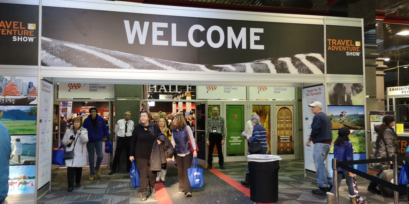 Visitors with tote bags walking through the Welcome gate of the Travel & Adventure Show, Donald E. Stephens Convention Center, Rosemont
