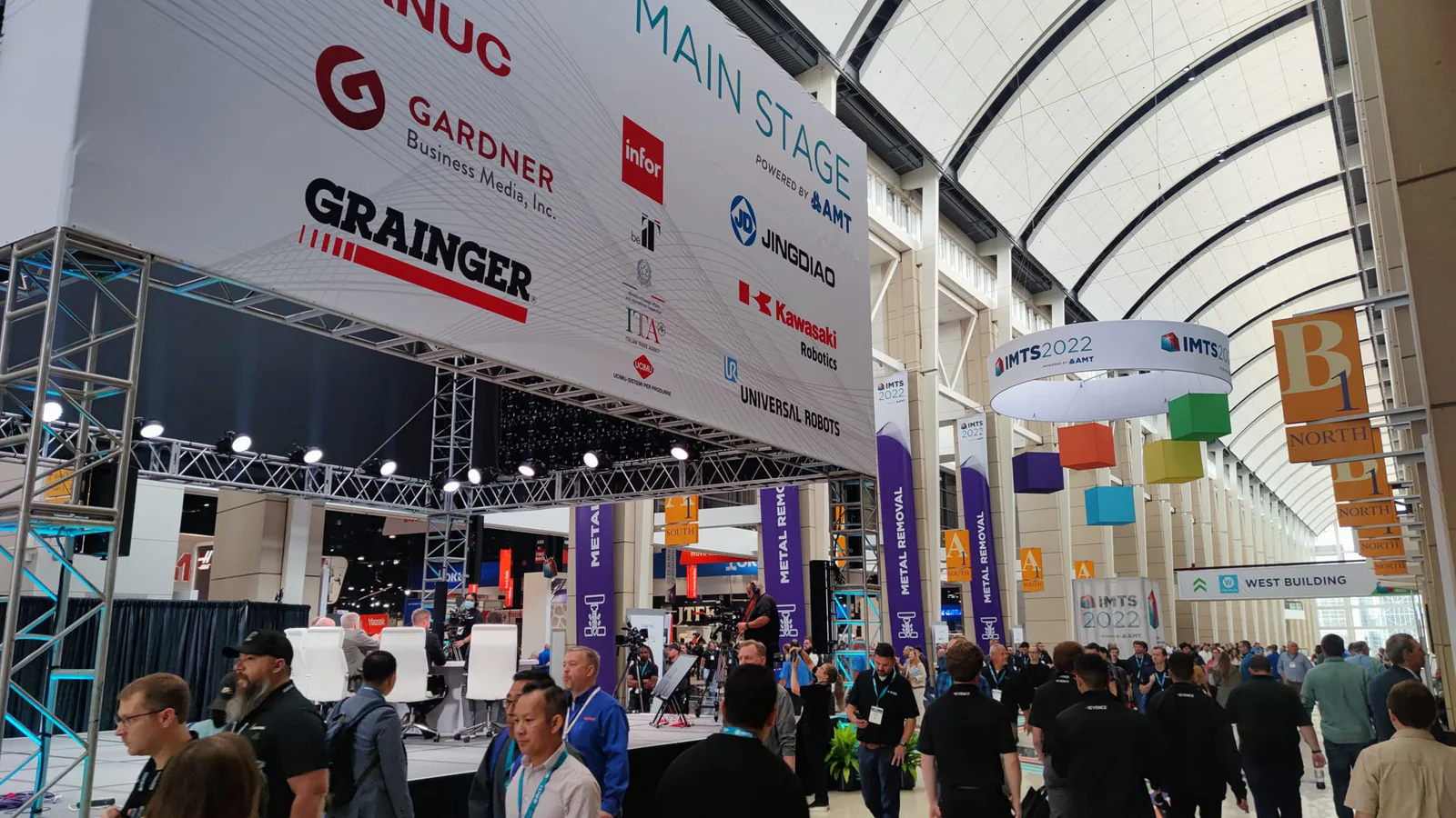 IMTS 2022 main stage with sponsor logos under the glass-vaulted concourse of McCormick Place in Chicago