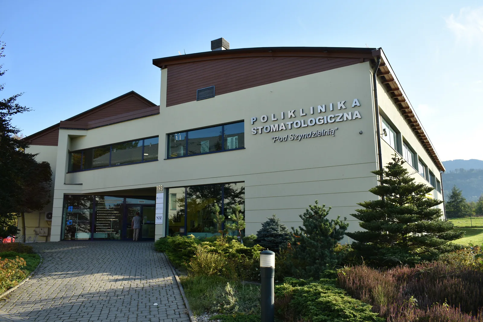 Polmedico Pod Szyndzielnią dental polyclinic building in Bielsko-Biała, with mountains in the background