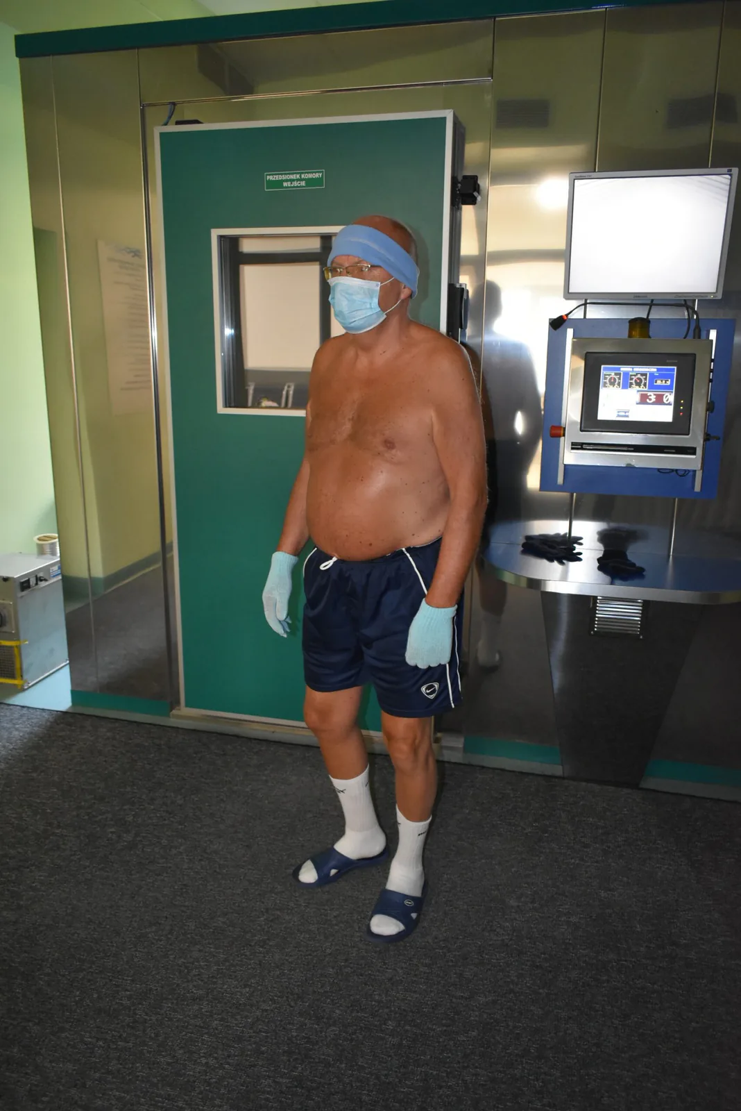 Visitor dressed for whole-body cryotherapy in front of the cryochamber entrance at Uzdrowisko Ustroń
