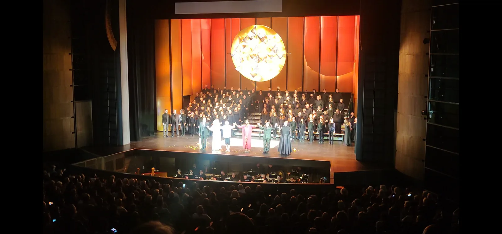 Cast and chorus taking a curtain call on stage after Chicago Opera Theater's King Roger, seen from the balcony