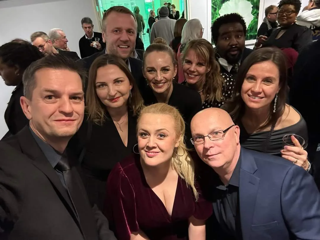 Group selfie of smiling guests at a crowded reception during the King Roger opera event in Chicago