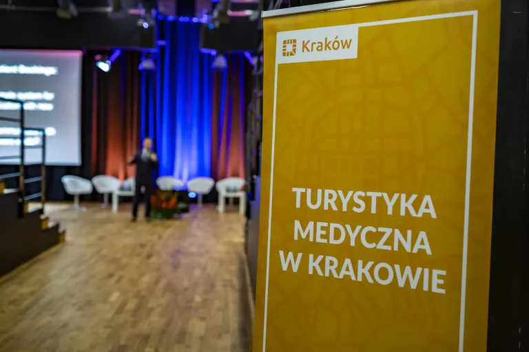 City of Kraków banner reading Medical Tourism in Kraków (in Polish), with a speaker on stage at the 4th Kraków Medical Tourism Congress