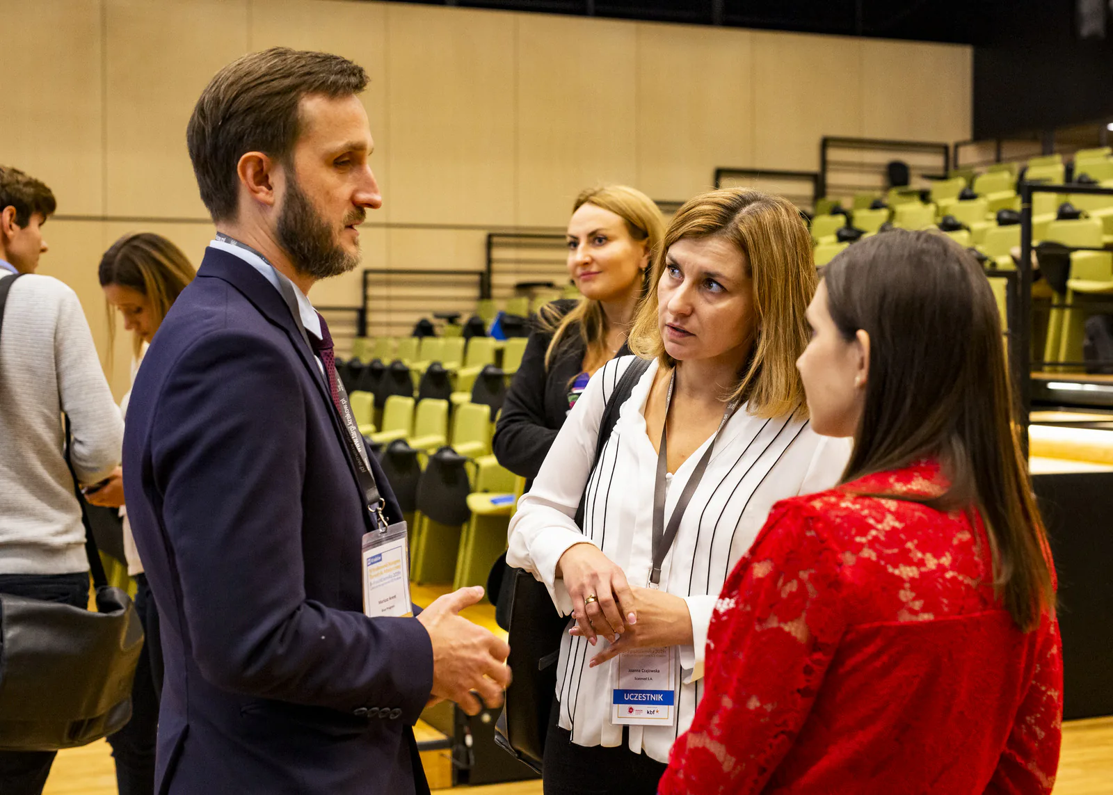 Congress participants with name badges talking during a break in the ICE Kraków auditorium
