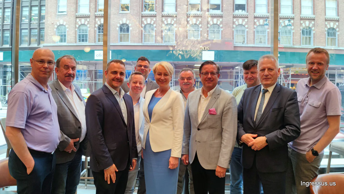 Delegation members meeting with the Pulaski Business Association, posing together by a window in New York