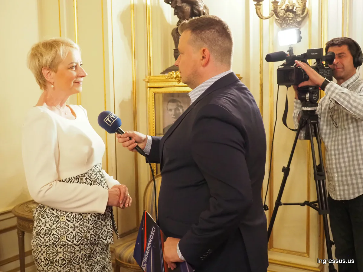 Delegation member giving an interview to a TVP reporter, with a camera operator filming in an ornate room