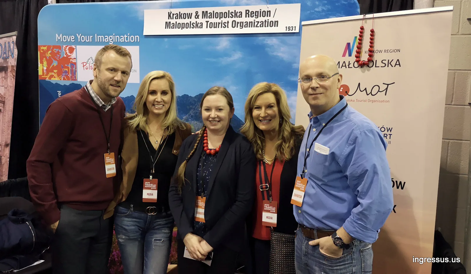 Five people with exhibitor and media badges posing at the Kraków and Małopolska Region booth at the 2020 Travel & Adventure Show