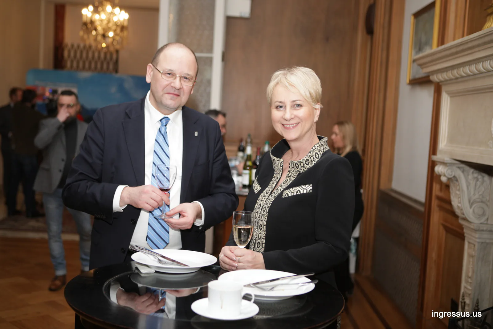 Man and woman with glasses of wine at a cocktail table during the reception at the Polish Consulate General in Chicago