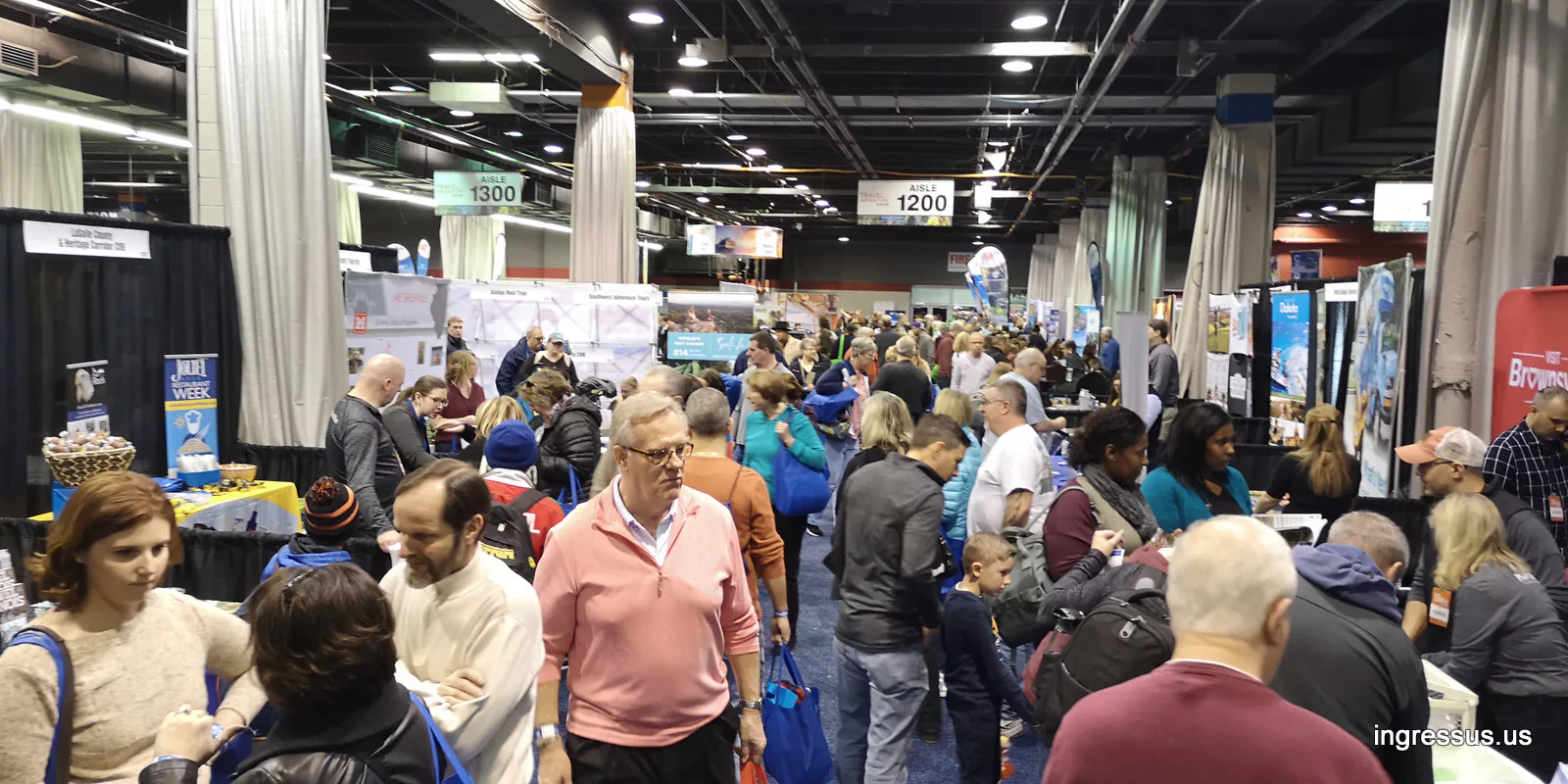 Crowded exhibition aisles lined with travel booths at the 2020 Travel & Adventure Show in Rosemont