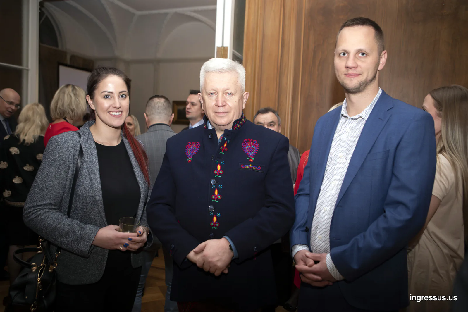 Three guests, one in an embroidered highlander jacket, at the reception at the Polish Consulate General in Chicago