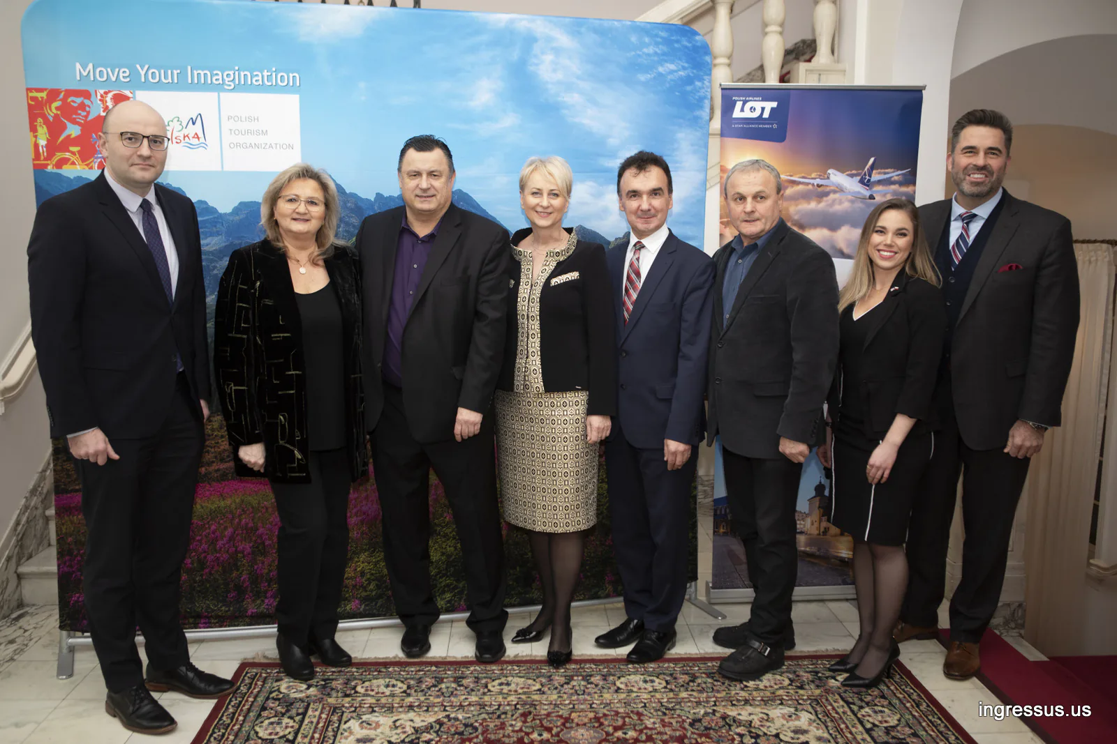 Group of guests posing between the Polish Tourism Organization backdrop and a LOT Polish Airlines banner at the Polish Consulate General