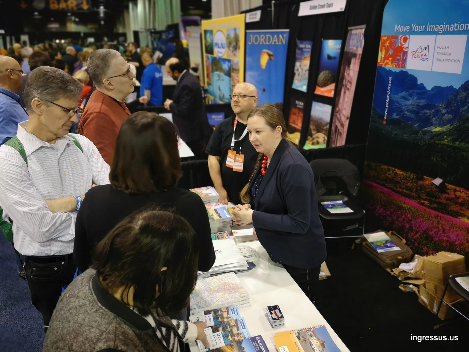 Visitors asking about Małopolska travel guides and maps at the Polish Tourism Organization booth at the Travel & Adventure Show