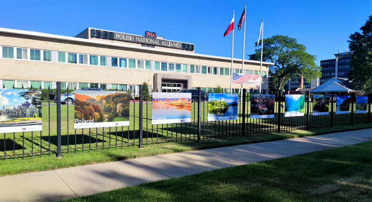 Polish National Alliance building in Chicago with Poland, Ready when you are travel posters along its fence and flags out front