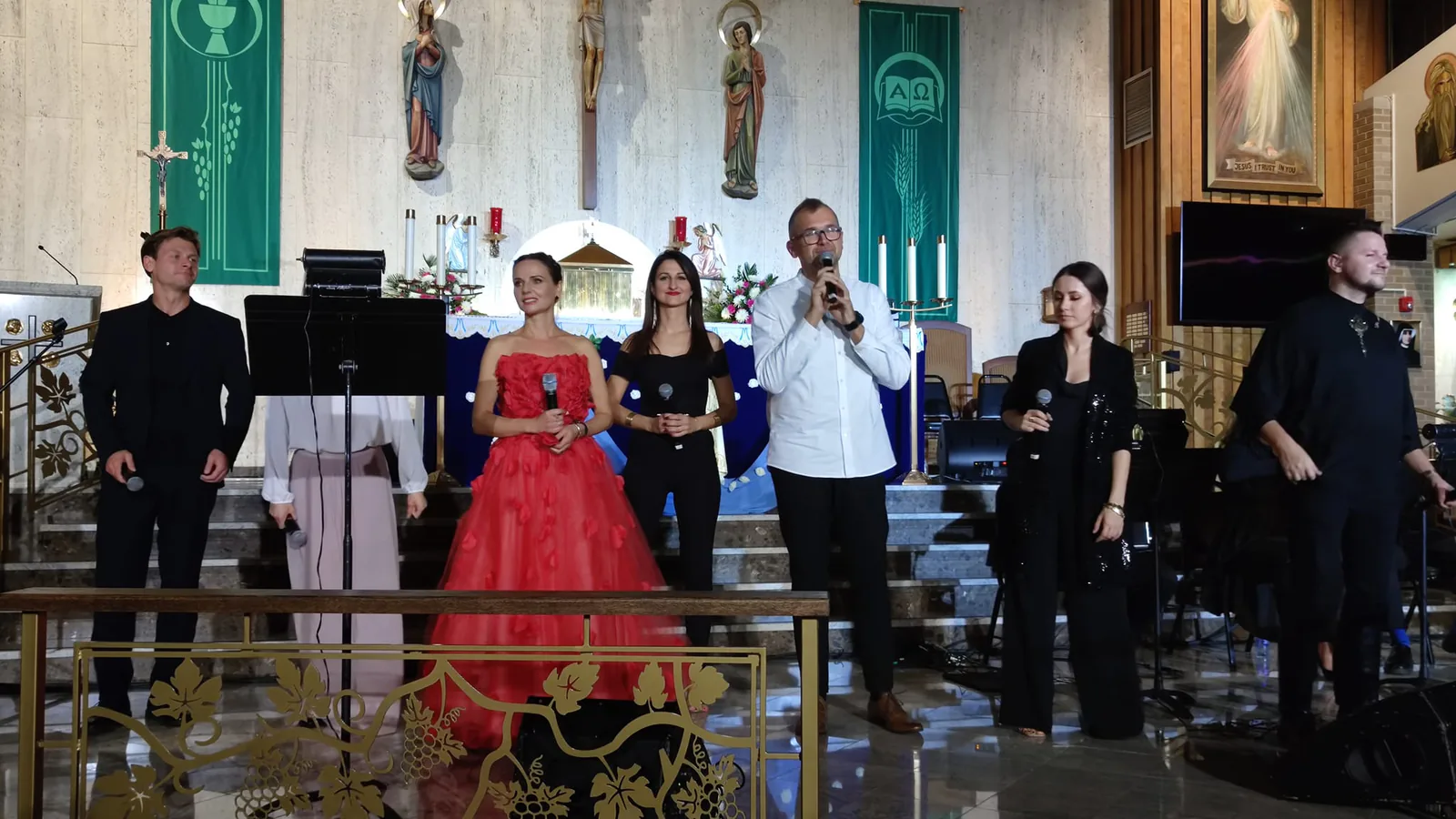 Singers of The Saint concert standing with microphones in front of the altar of a Chicago-area parish church
