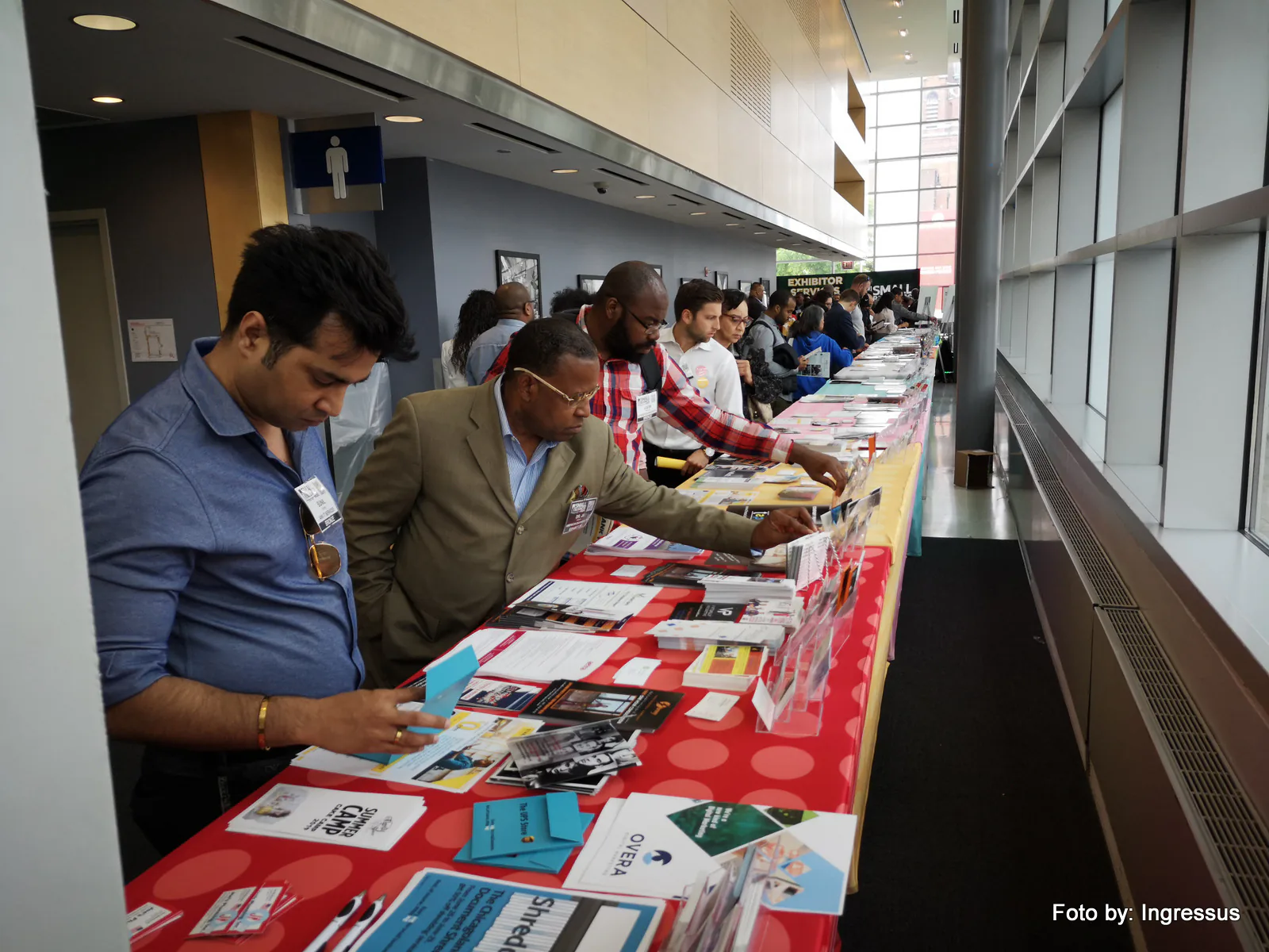 Attendees browsing flyers and brochures on a long table in the hallway at Small Business Expo 2019 in Chicago
