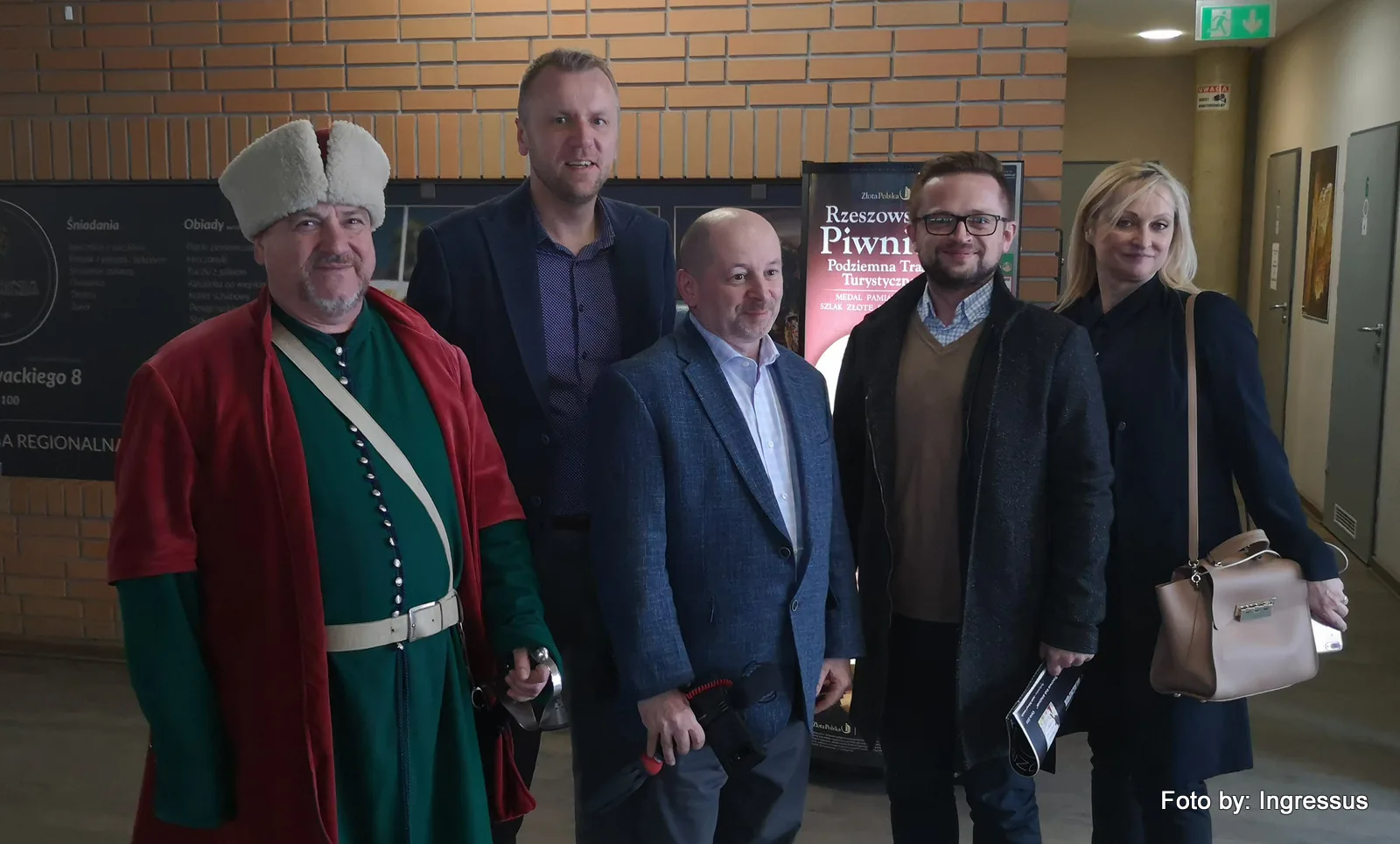 Study tour group with a guide in a traditional Polish nobleman's costume at the Rzeszów Underground Tourist Route