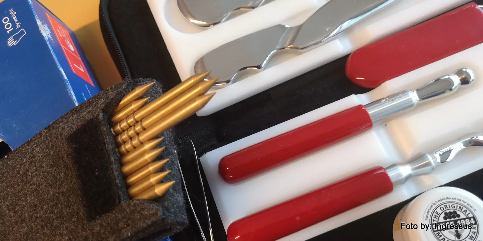Metal massage and therapy tools with red handles and a row of gold-colored applicators in a case at a Polish spa