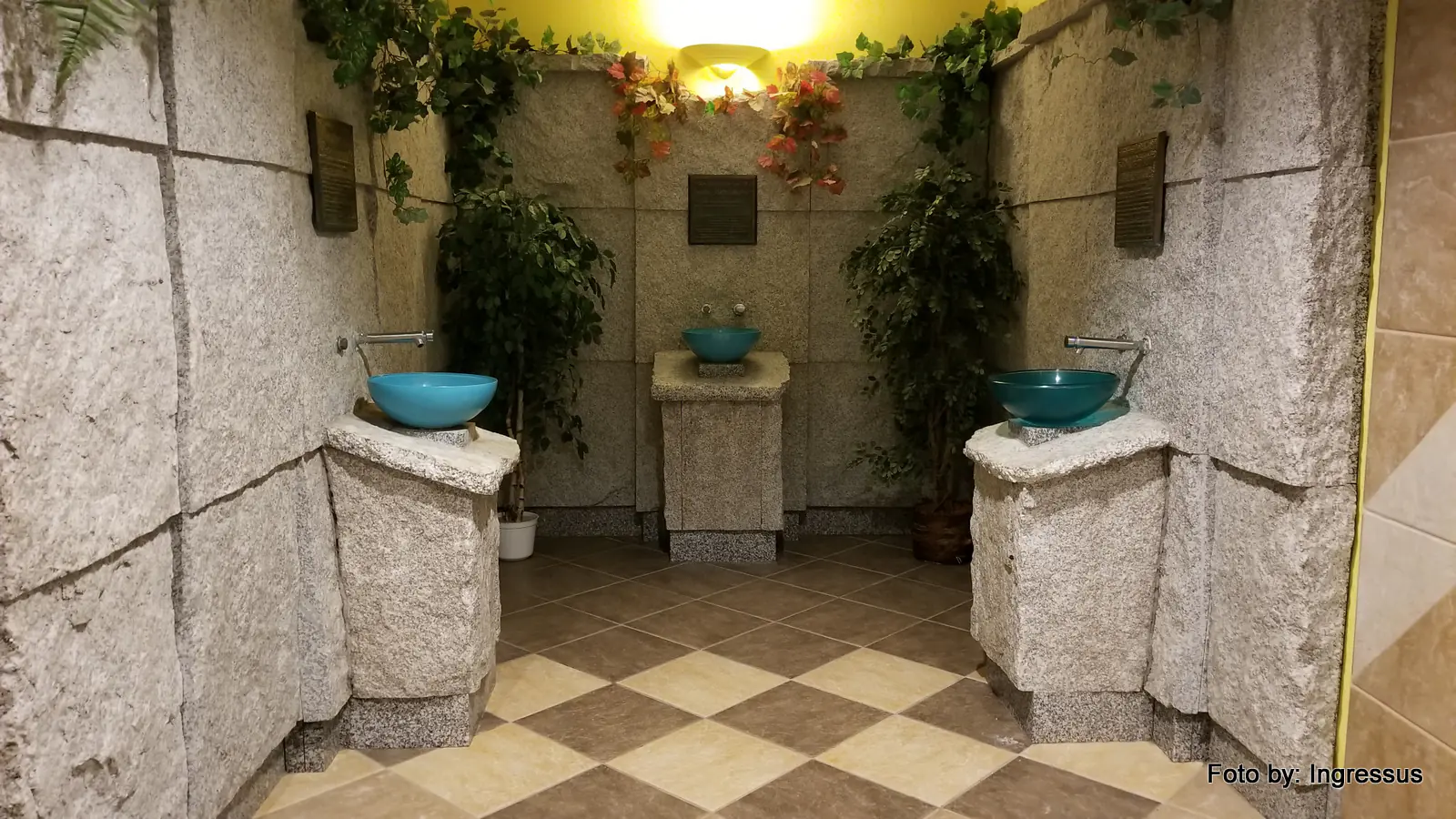 Mineral water taps with turquoise basins on stone pedestals in a drinking hall at a Polish spa