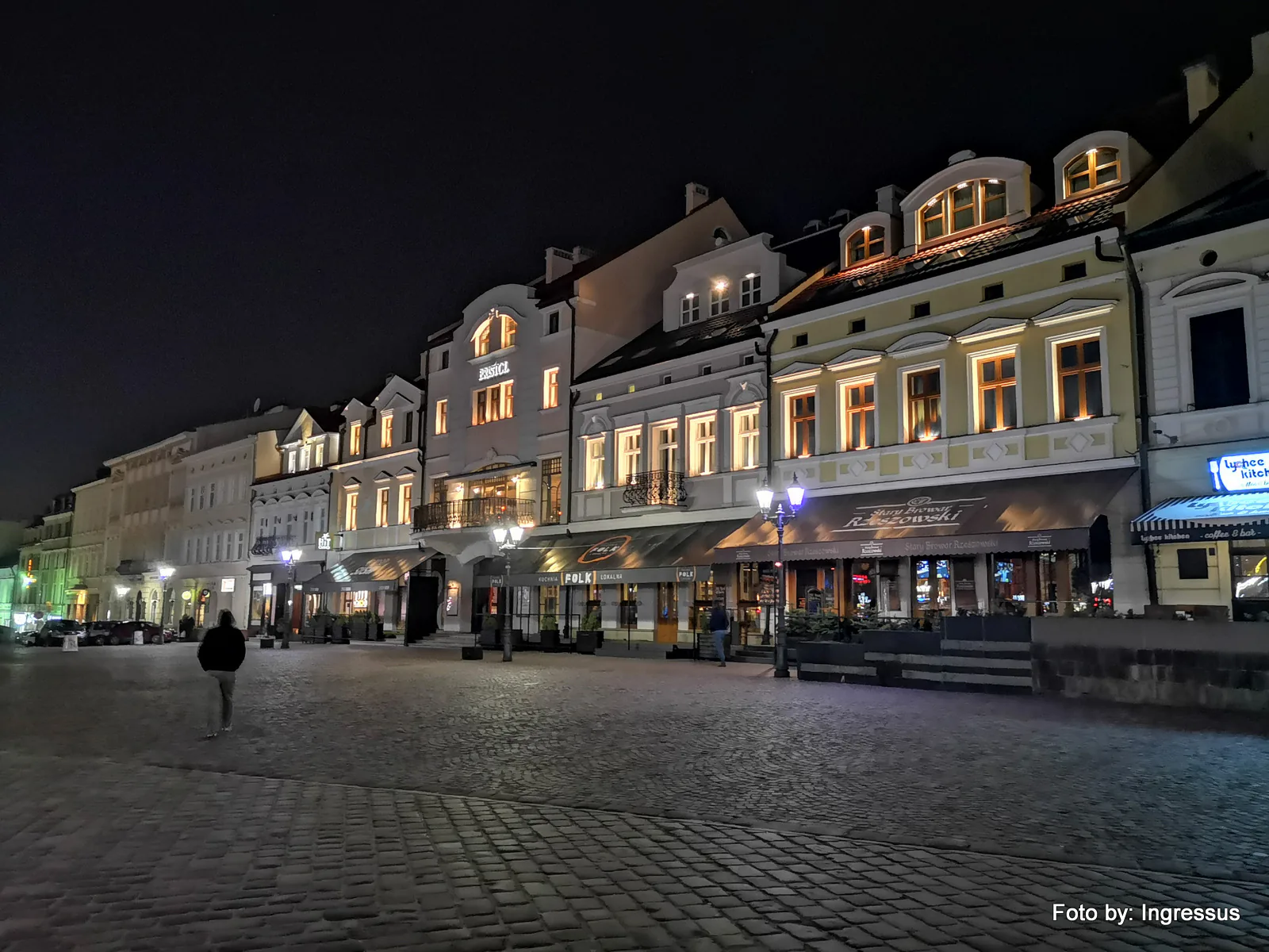 Illuminated historic townhouses and restaurants on the cobbled market square in Rzeszów at night during the 2019 study tour