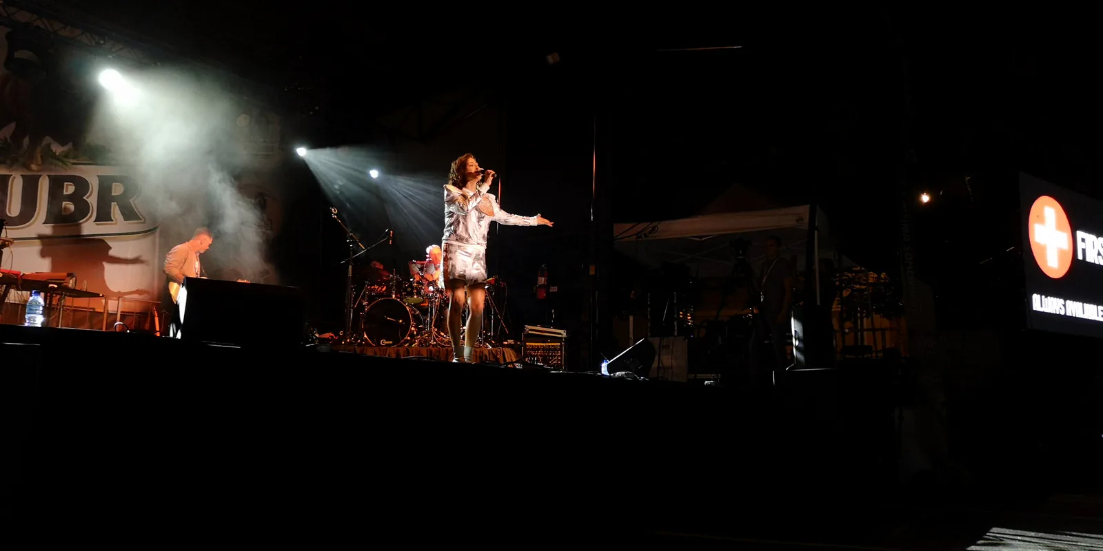 Natalia Kukulska singing under spotlights on the dark Taste of Polonia stage, with her band playing behind her