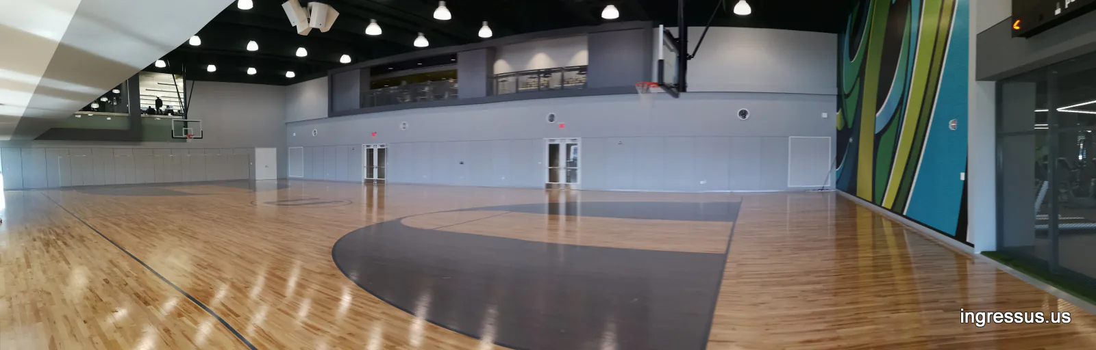 Indoor basketball court with a hardwood floor and a colorful mural wall at United Wholesale Mortgage headquarters