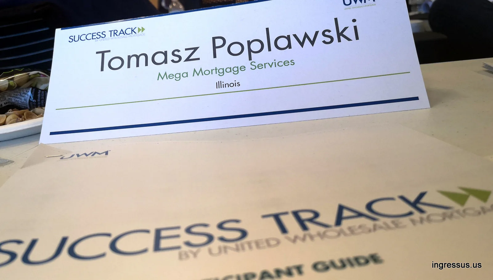 Success Track name card for Tomasz Popławski of Mega Mortgage Services, Illinois, on a UWM participant guide at the training